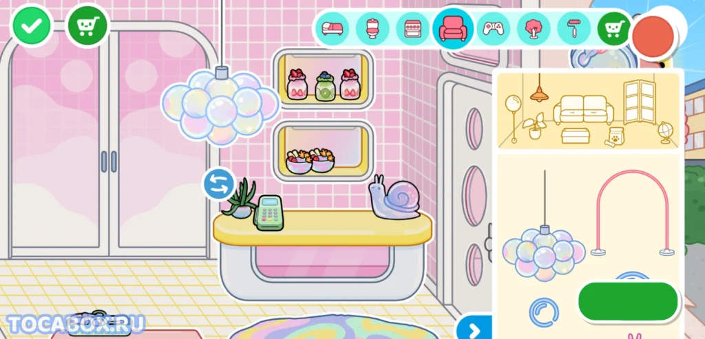 Ресепшен Bubble Bop Spa в Toca Boca World Интерьер стойки ресепшен в Bubble Bop Spa из Toca Boca World с розовыми плитками, подвесным светильником из пузырей, кассовым аппаратом, декоративной улиткой, полками с банками и чашами, а также стеклянными дверьми с видом на улицу.
